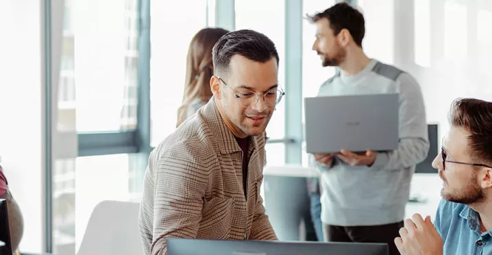 Foto mostra grupo de funcionários trabalhando no escritório