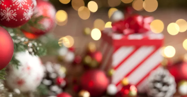 Imagem mostra uma mesa de Natal com um presente ao fundo