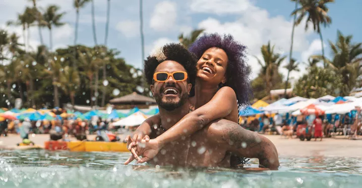 Foto mostra um casal curtindo férias na praia