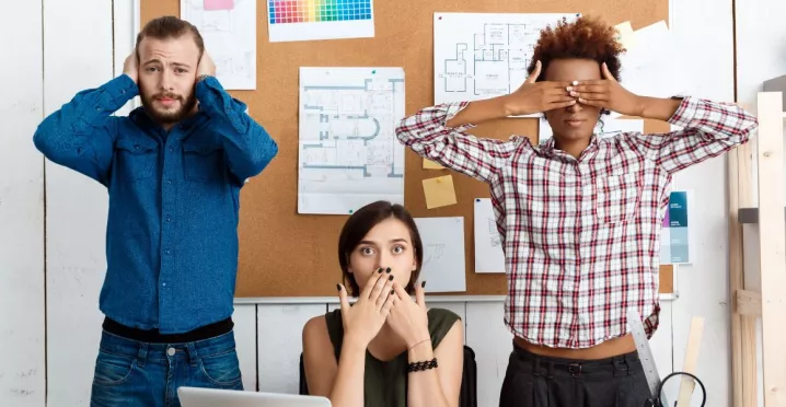 três pessoas imitando os “três macacos sábios”, da cultura japonesa.