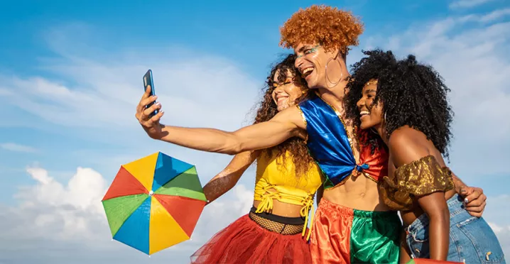 pessoas com roupa de carnaval tirando foto.
