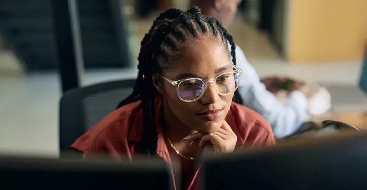 mulher olhando para computador pensativa.