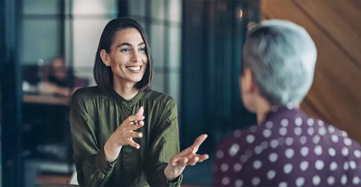 duas mulheres conversando em um ambiente corporativo 