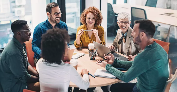 time conversando em torno de uma mesa dentro de escritorio.