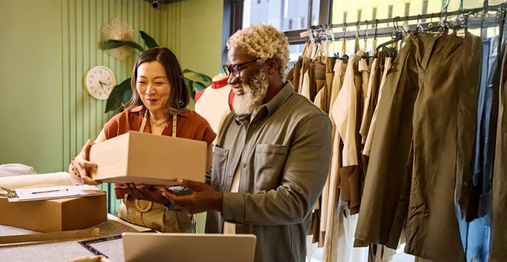 Microempresária trabalha com seu funcionário na loja de roupas