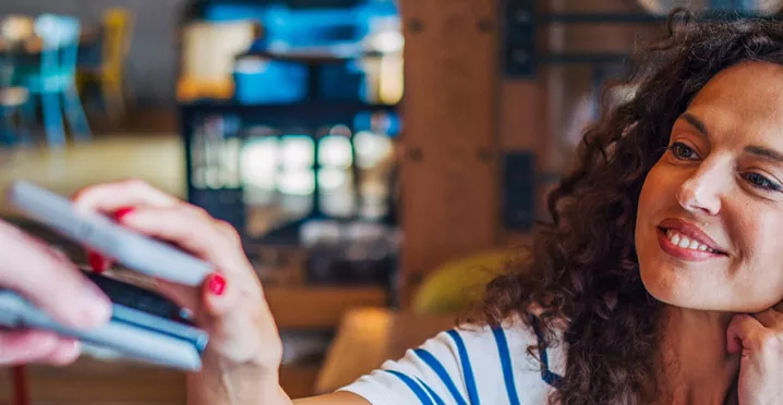 mulher pagando compra com celular.