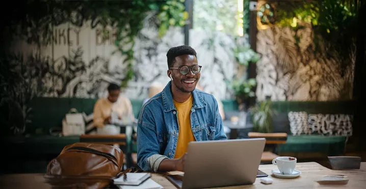 homem sorrindo enquanto usa o notebook.