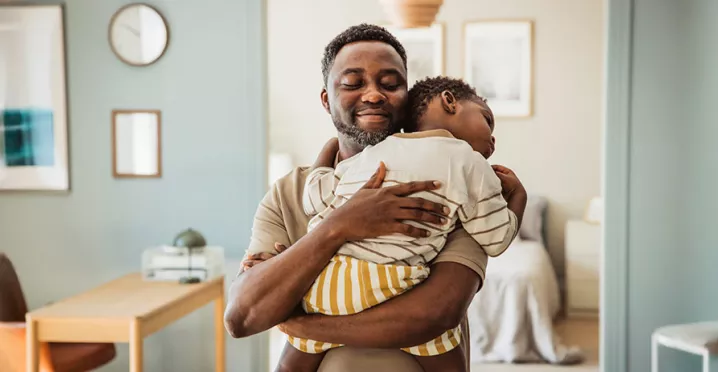 pai segurando o filho no colo.
