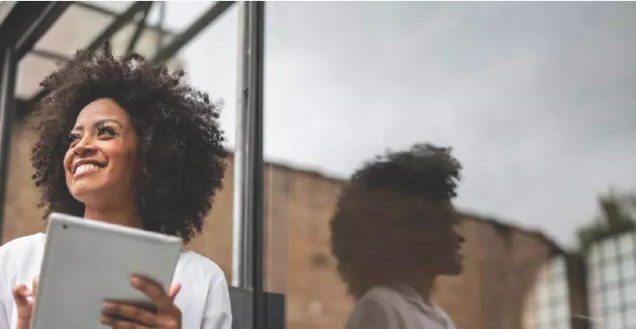 Mulher negra com tablet sorrindo