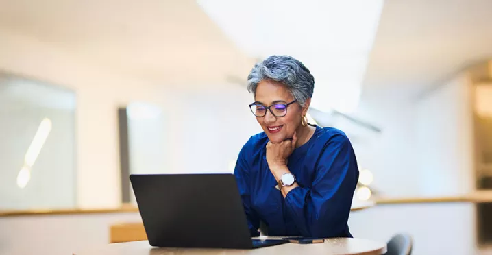 mulher sorrindo para computador.