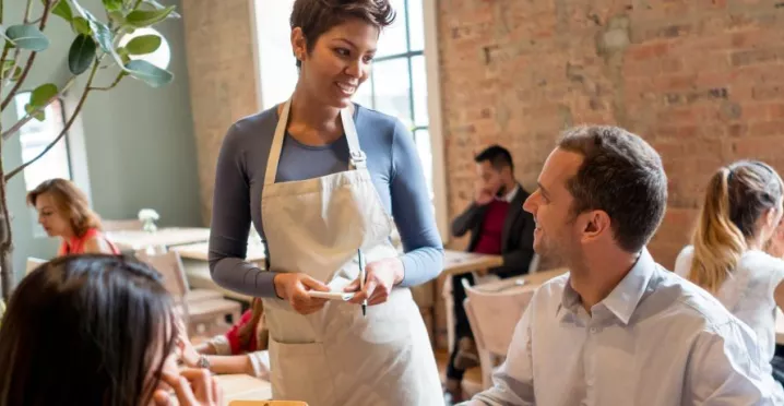 homem em restaurante sendo atendido por uma mulher
