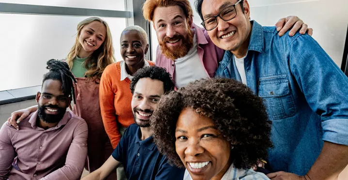 equipe de trabalho diversa sorrindo para selfie.