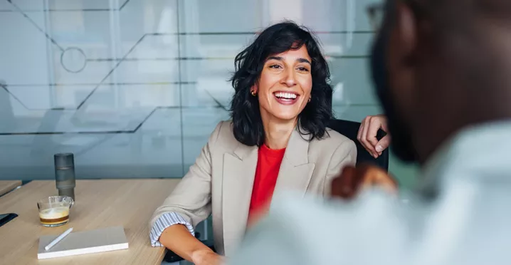 mulher e homem conversando e sorrindo em escritório.