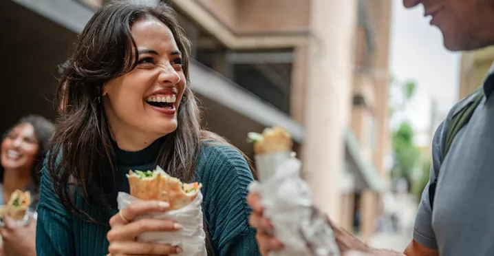 mulher almoçando e sorrindo.