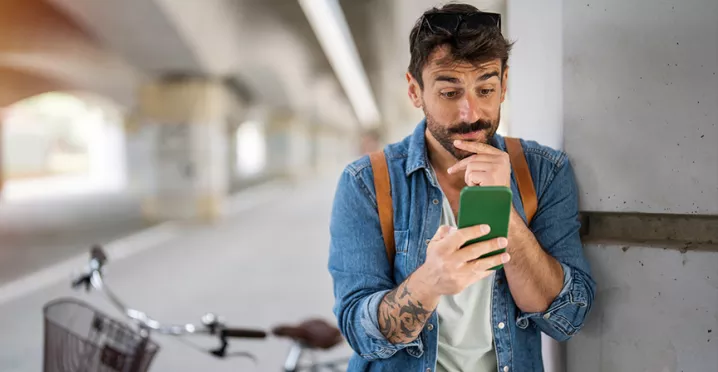 homem olhando o celular depois de andar de bicicleta.