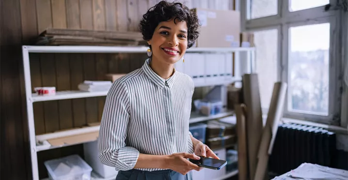 mulher sorrindo em frente a seu empreendimento.