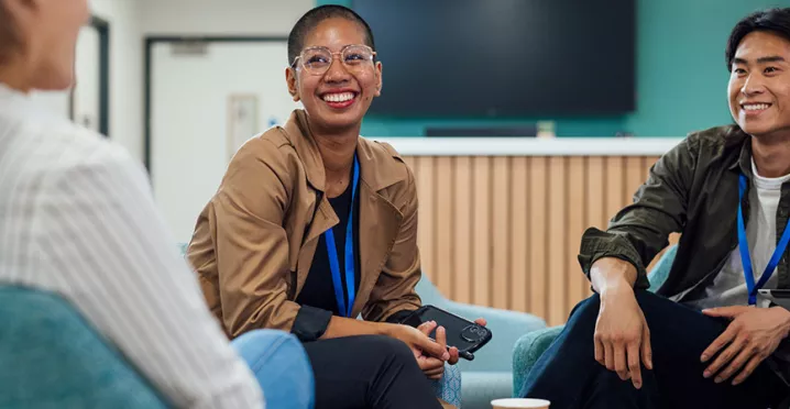 pessoas sorrindo em roda de conversa no trabalho.