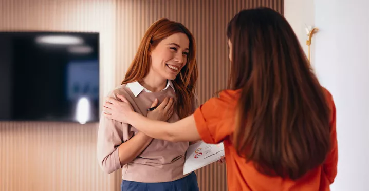 duas mulheres se abraçando no trabalho.