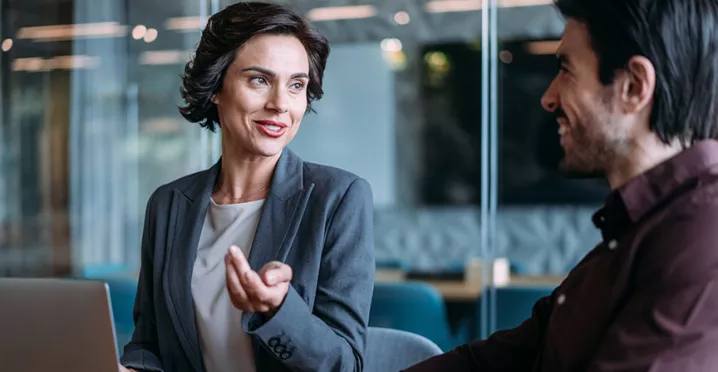duas pessoas conversando no trabalho.