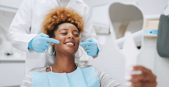 mulher sorrindo na cadeira de dentista.