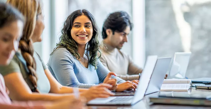 mulher sorrindo para companheiros de estudos.