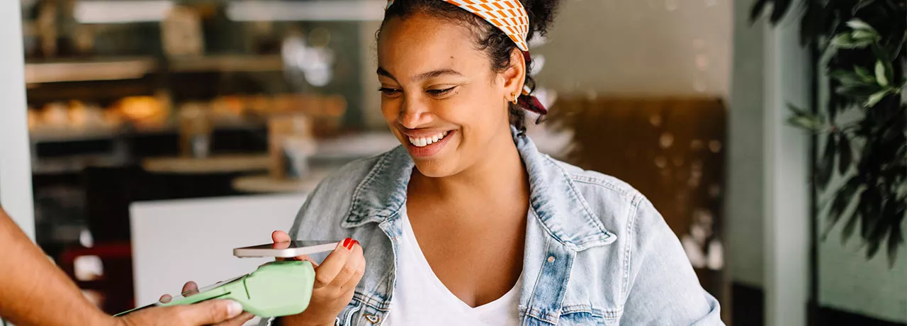 Mulher paga conta em café usando seu cartão Pluxee no Apple Pay