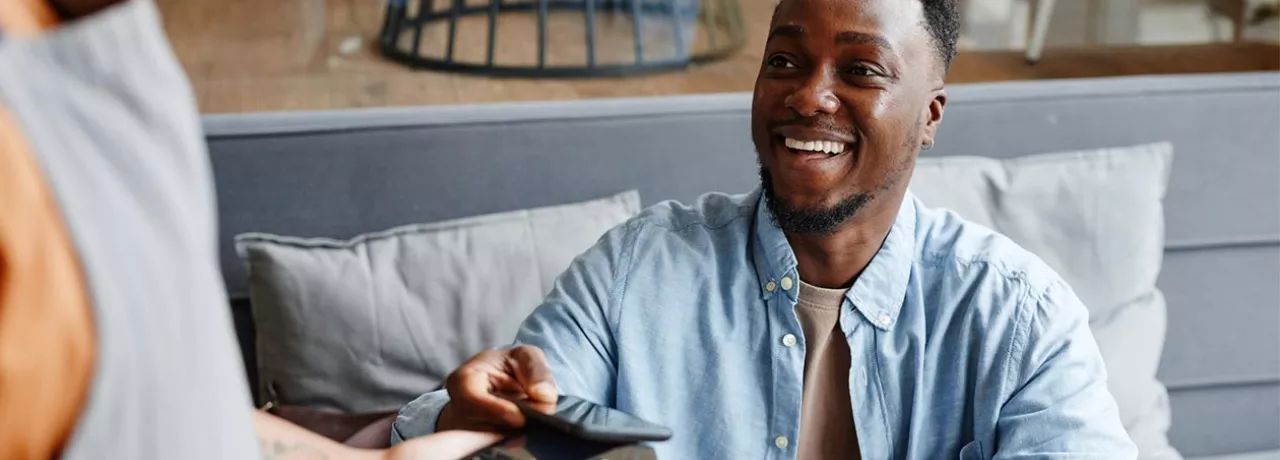 Homem paga conta com vale-refeição Pluxee no seu restaurante favorito