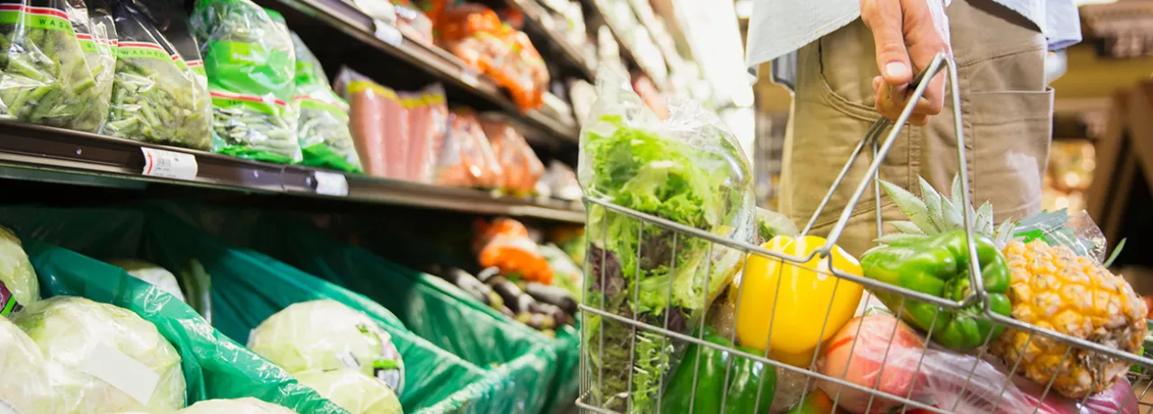 Pessoa escolhe verduras e legumes frescos em um supermercado
