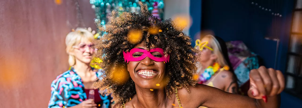 Mulher se diverte em festa de Carnaval. Veja como orientar sua equipe sobre segurança no feriado