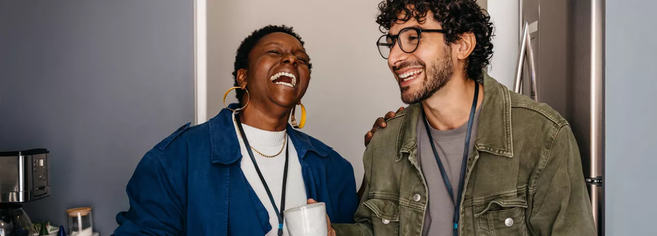 Dois colegas de trabalho se divertem no café da empresa durante o intervalo