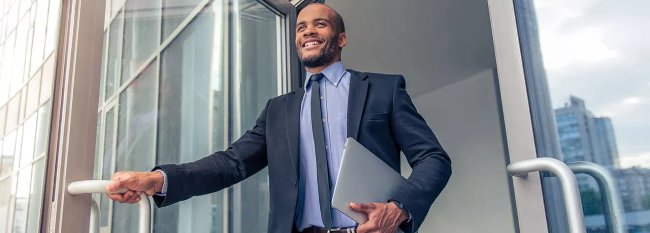 Jovem executivo sai feliz do escritório para curtir sua short friday