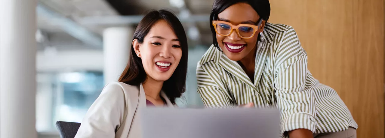 Duas colegas de trabalho contribuem para a evolução de um projeto na empresa