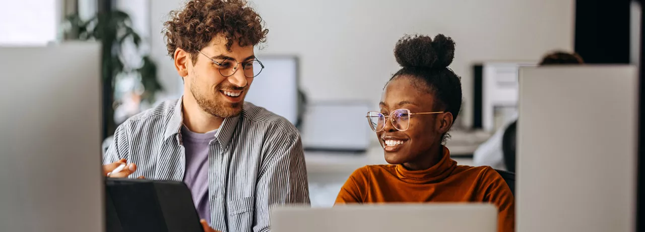 Dois colegas de trabalho veem juntos o andamento de um projeto