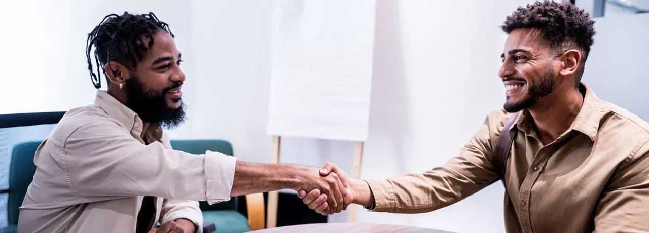 O novo funcionário cumprimenta com um aperto de mão um de seus novos colegas de trabalho