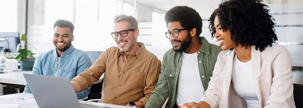 Equipe de quatro pessoa trabalha junta em um escritório