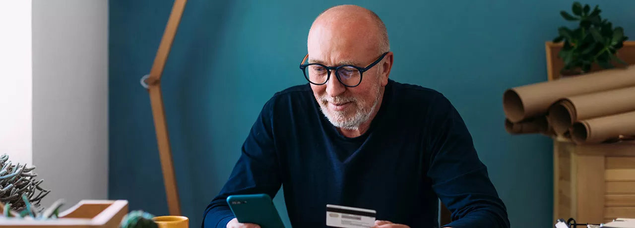 Foto de um homem usando o celular em sua casa