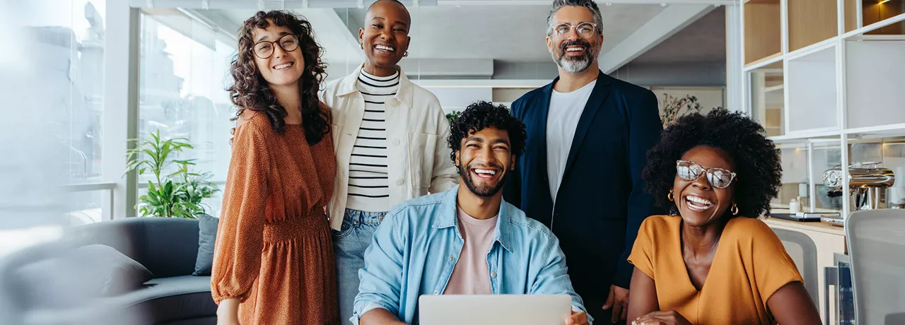 Imagem mostra uma equipe de trabalho motivada e feliz no escritório