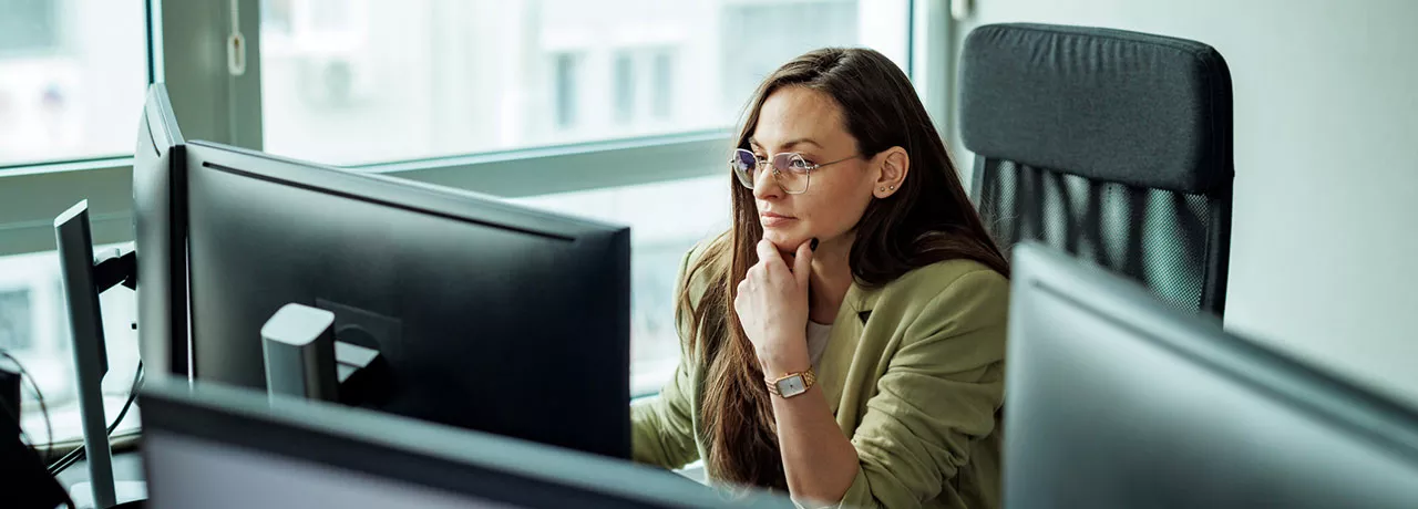 mulher olhando para computador pensativa.