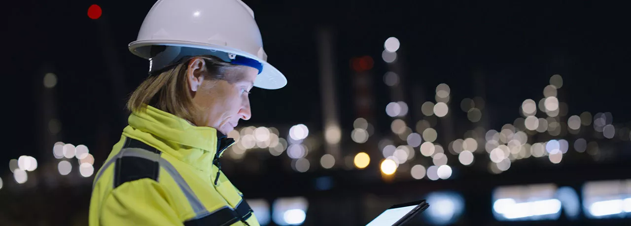profissional com capacete de proteção trabalhando à noite.
