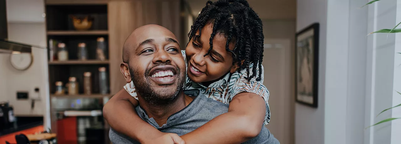 Pai carrega o filho nas costas em uma brincadeira