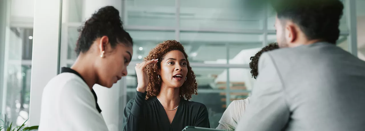 pessoas em uma reunião discutindo sobre uma matriz de competências.