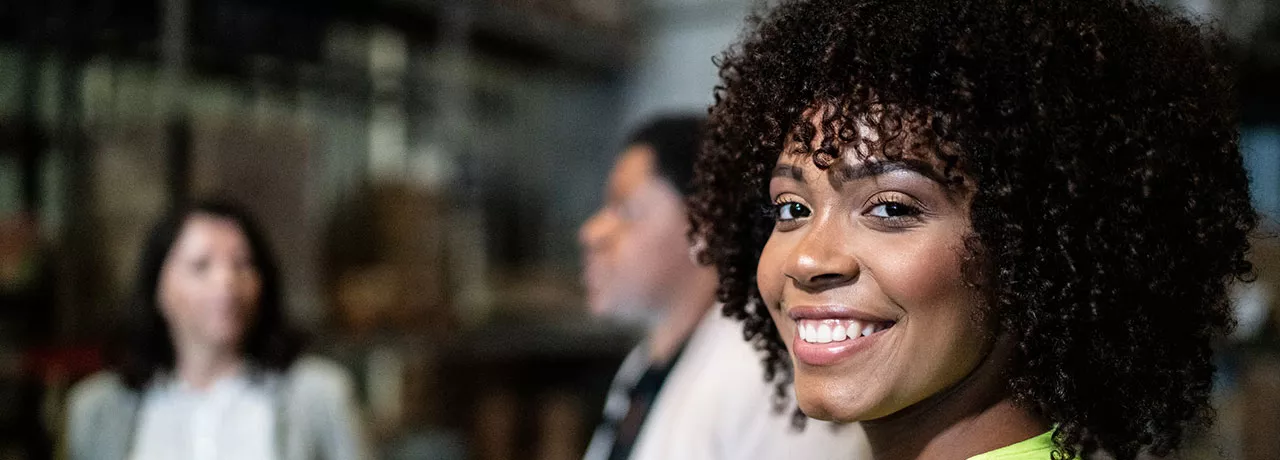 Profissional sorri na fábrica em que trabalha