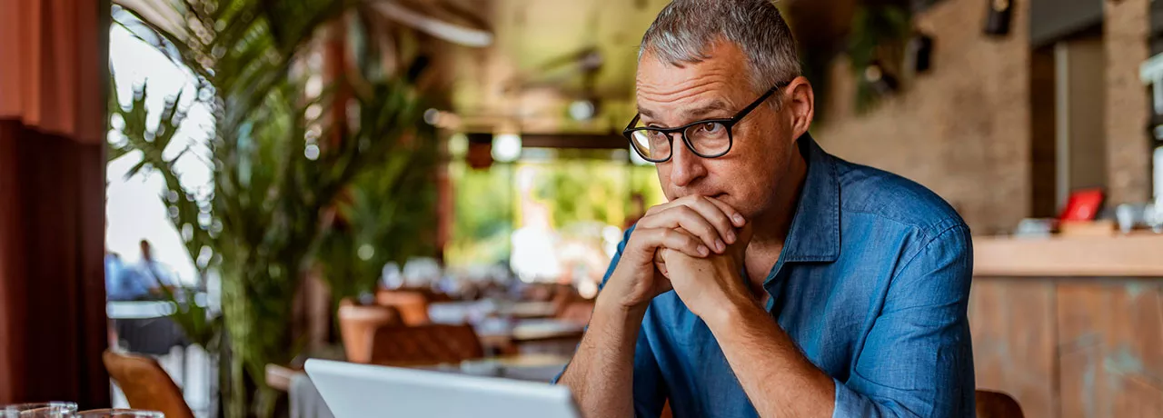 homem olhando para computador preocupado.