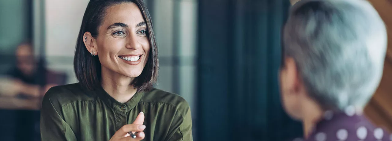 duas mulheres conversando felizes.