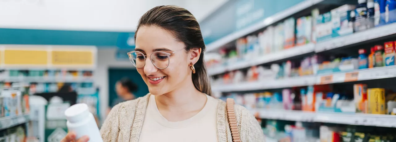 Mulher confere suplemento em farmácia