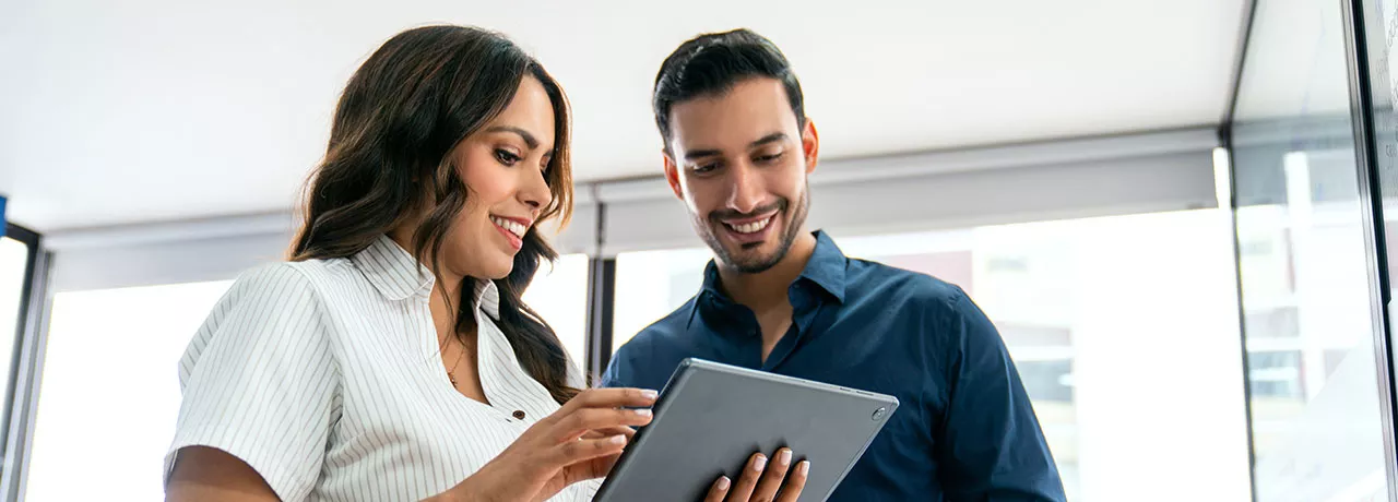 uma mulher e um homem olhando para algo em um tablet.