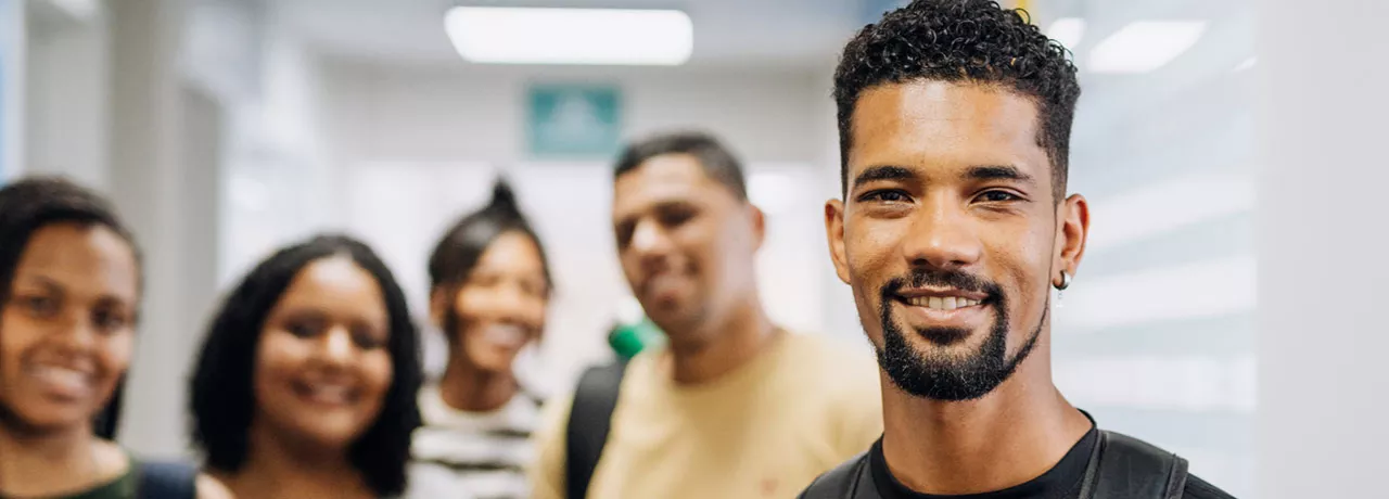 vários jovens sorrindo em ambiente corporativo.