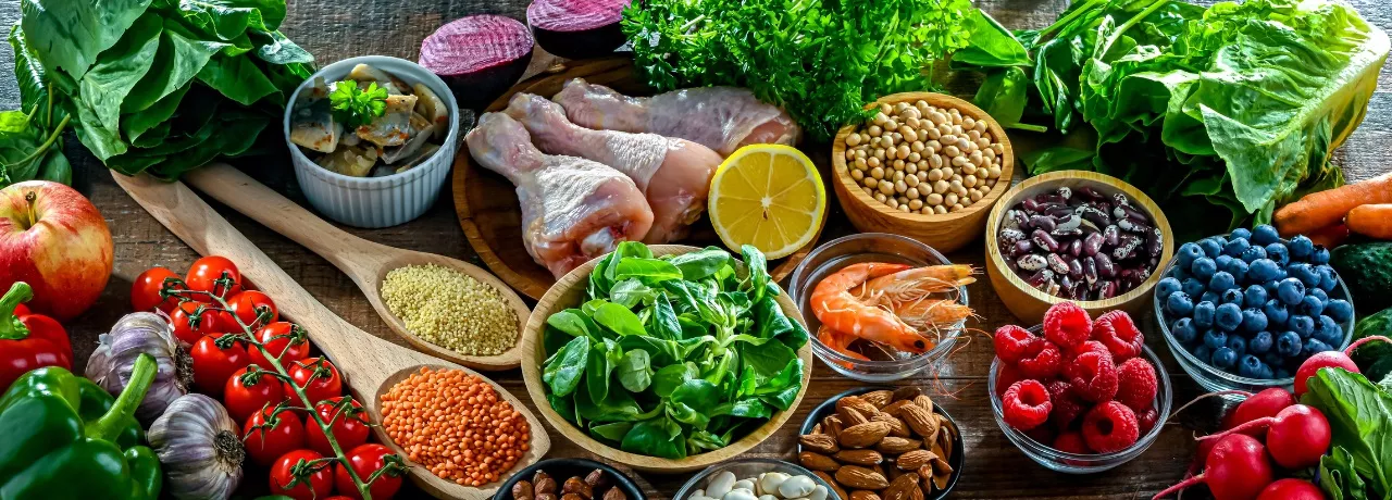 A imagem mostra temperos, frutas, proteínas e saladas todas juntas