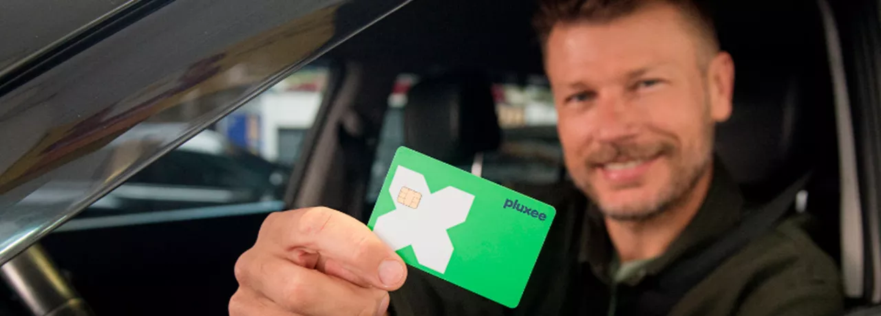 Rodrigo Hilbert dirigindo com o cartão Pluxee na mão