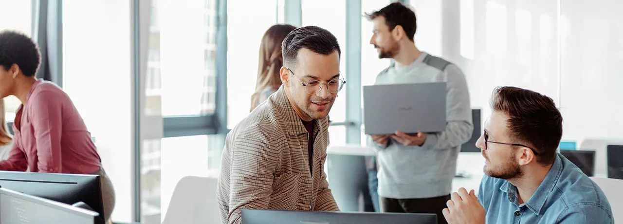 Foto mostra grupo de funcionários trabalhando no escritório